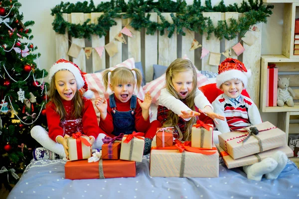 Ομάδα παιδιών με το κόκκινο καπέλο με τα δώρα Χριστουγέννων — Φωτογραφία Αρχείου