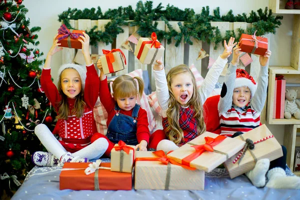 Grupa dzieci w czerwonym kapeluszu z prezenty świąteczne — Zdjęcie stockowe
