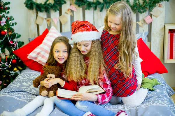 Маленькі дівчата читають книгу, Різдвяний час — стокове фото