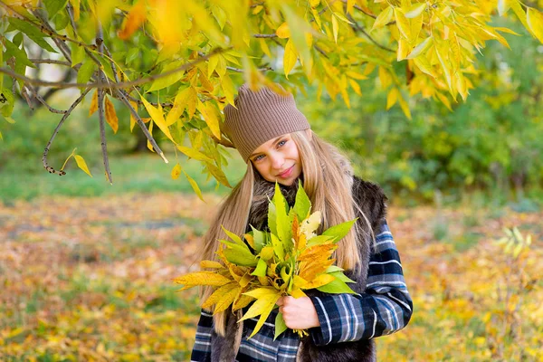 Маленька дівчинка в осінньому парку з листям — стокове фото