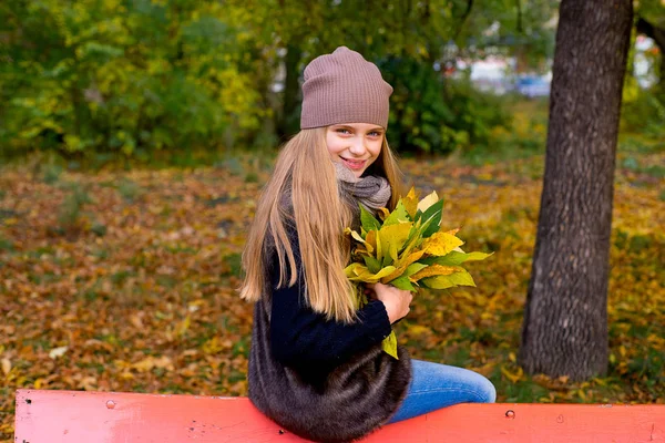 Девочка-подросток в осеннем парке с лепестками — стоковое фото