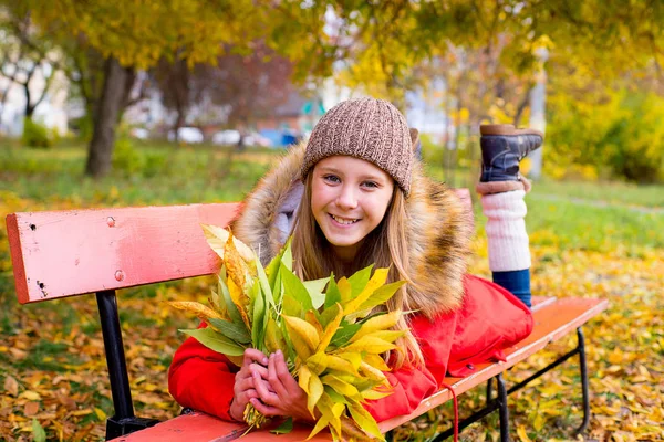 Menina pré-adolescente no parque de outono com folhas — Fotografia de Stock