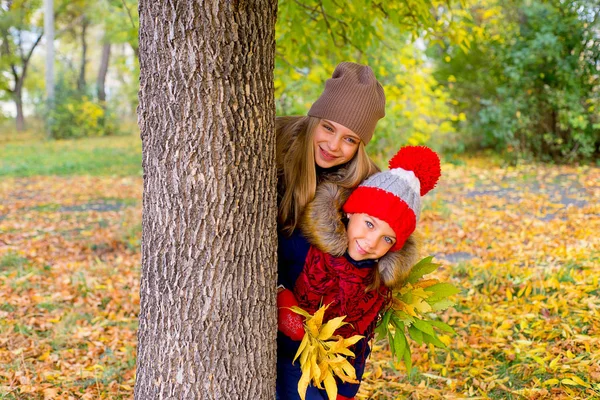 Little girls in autumn park with leafs — Stock Photo, Image