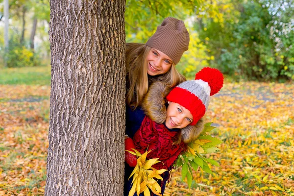 Kleine Mädchen im Herbstpark mit Blättern — Stockfoto