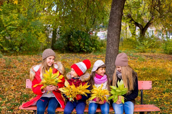 Grupa dziewcząt w jesienny park na brench — Zdjęcie stockowe