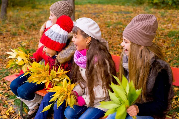 Group of girls in autumn park on the brench — Stock Photo, Image