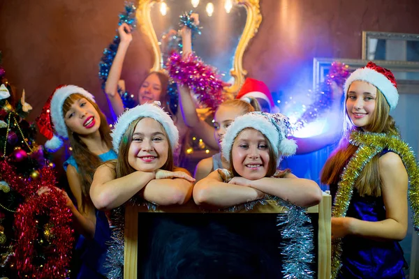 Group of young girls celebrating Christmas. Black board — Stock Photo, Image