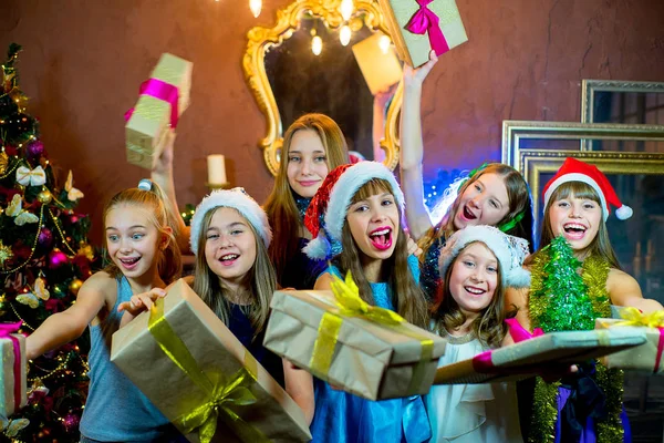 Grupp av glada unga flickor som firar jul. Gåvor — Stockfoto