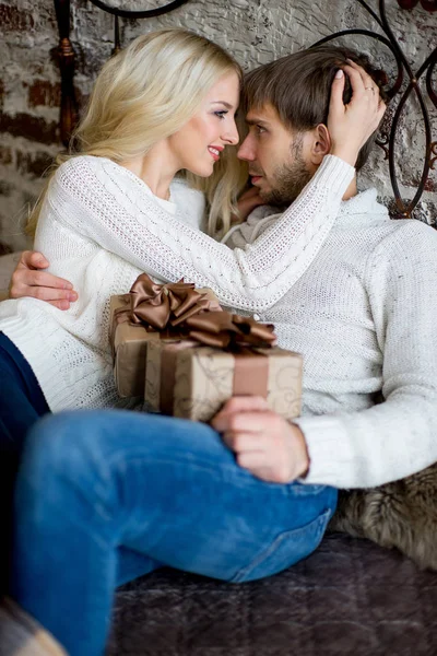 Szczęśliwa para kochanków w biały swetry dać sobie nawzajem prezenty — Zdjęcie stockowe