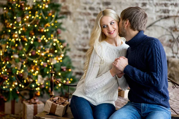 Happy couple of lovers in pullovers give each other gifts — Stock Photo, Image