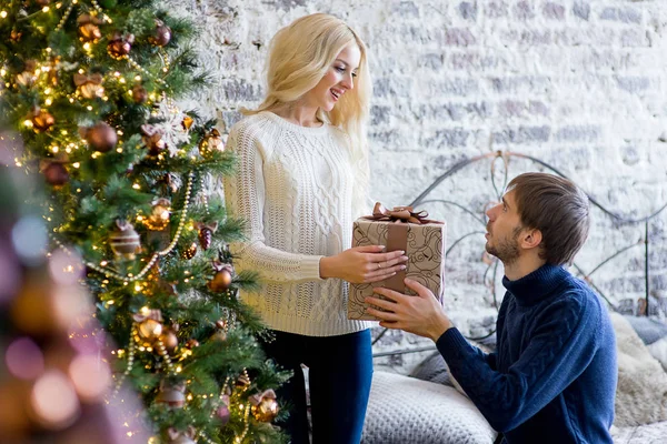 Homem fazendo um presente para a menina enquanto eles estão decorando o Natal — Fotografia de Stock