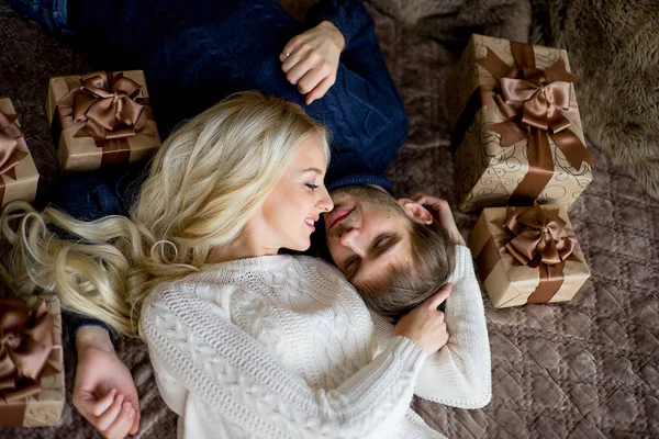 Feliz pareja de amantes en suéteres se mira el uno al otro mintiendo —  Fotos de Stock