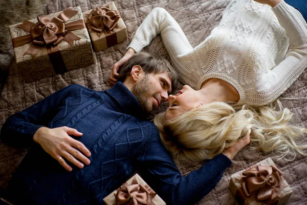 Šťastný pár milenců v svetry vypadá sebe ležící — Stock fotografie