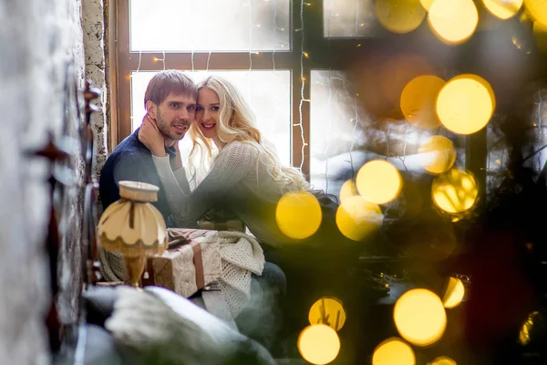 Casal feliz de amantes em pulôveres dar uns aos outros presentes sentados — Fotografia de Stock