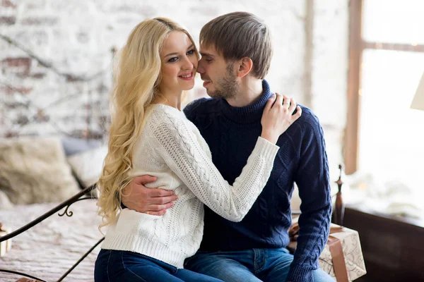 Šťastný pár milenců v pulovry podívat navzájem sedí — Stock fotografie
