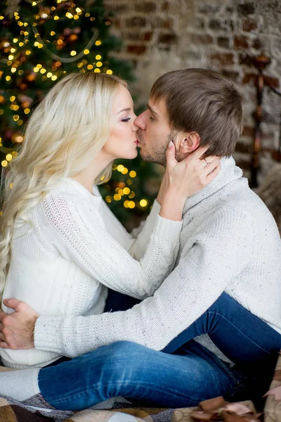 Szczęśliwa para kochanków w swetry patrzeć sobie siedzi — Zdjęcie stockowe