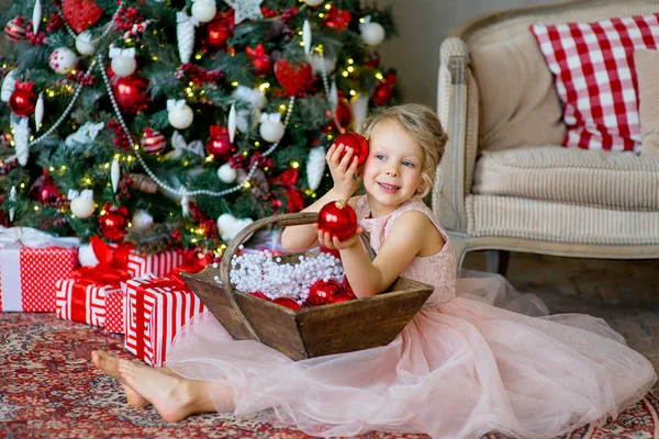 Little girl looks at Christmas decorations — Stock Photo, Image