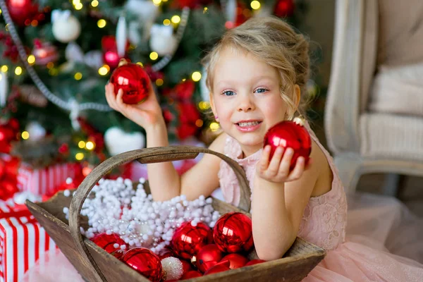 Little girl looks at Christmas decorations — Stock Photo, Image