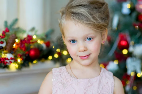 Niña mira a la cámara cerca del árbol de Navidad — Foto de Stock