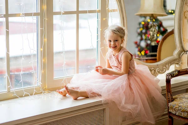 Aranyos kis lány ült az ablaknál — Stock Fotó