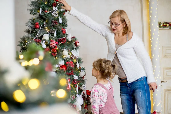 Mädchen mit Großmutter schmückt Weihnachtsbaum — Stockfoto