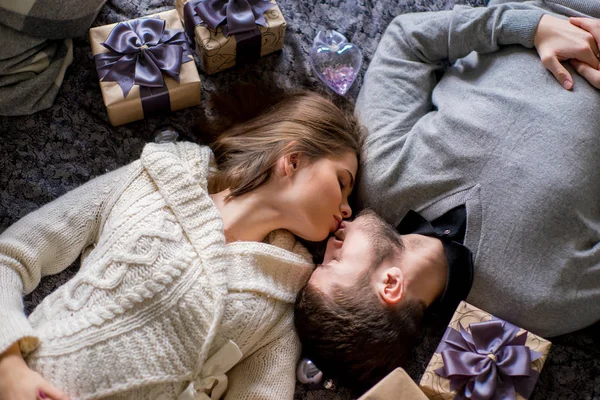 Casal feliz de amantes deitado entre presentes de Natal — Fotografia de Stock