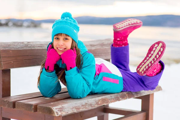 Jeune fille allongée sur le banc — Photo