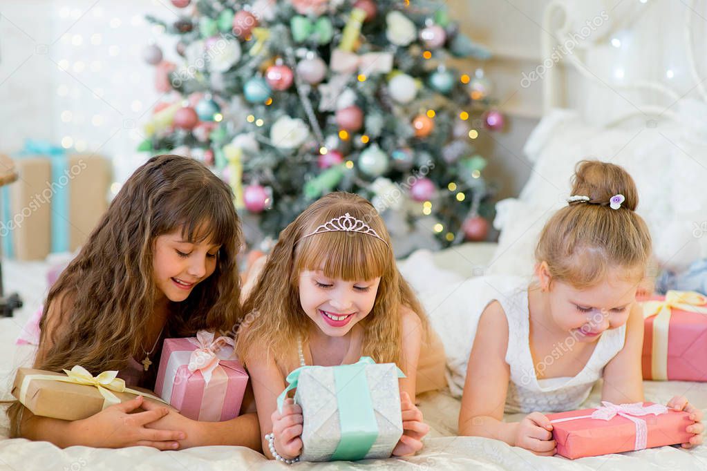 Three young happy girls with Christmas gifts
