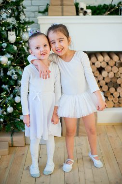 İki genç bale dansçısı sarılmak Noel ağacı yakınındaki