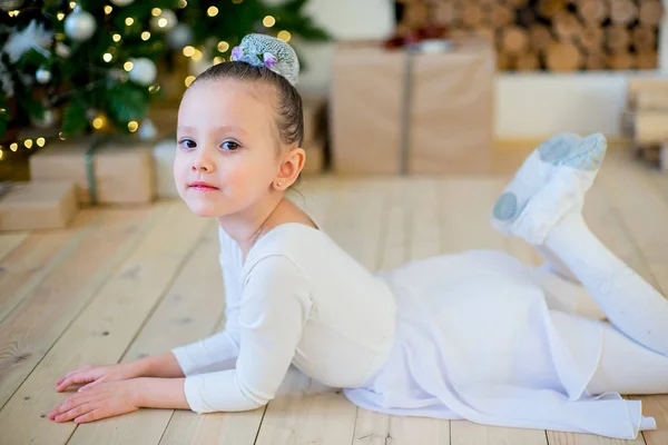 Joven bailarina de ballet tendida cerca del árbol de Navidad —  Fotos de Stock