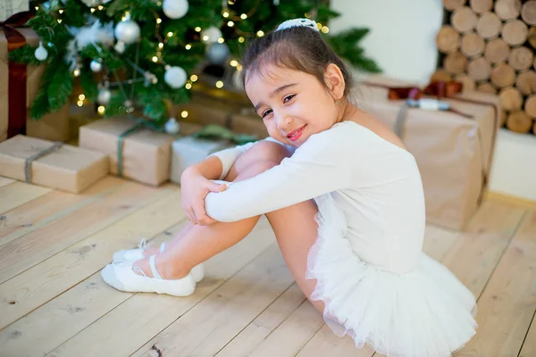 Joven bailarina de ballet sentada cerca del árbol de Navidad —  Fotos de Stock