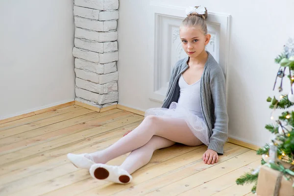 Junge Balletttänzerin sitzt am Weihnachtsbaum — Stockfoto