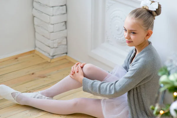 Joven bailarina de ballet sentada cerca del árbol de Navidad — Foto de Stock