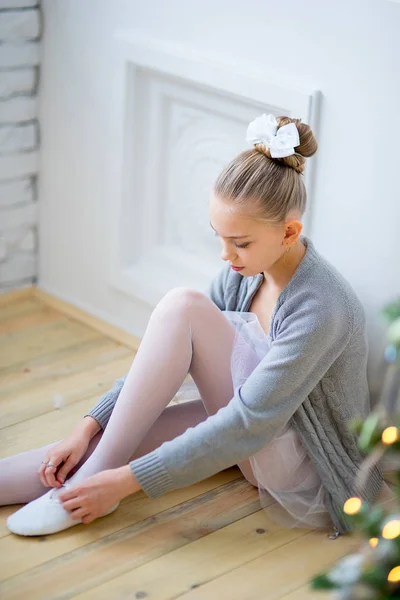 Junge Balletttänzerin sitzt am Weihnachtsbaum — Stockfoto