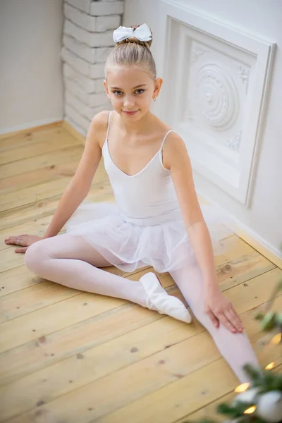 Joven bailarina de ballet sentada cerca del árbol de Navidad —  Fotos de Stock