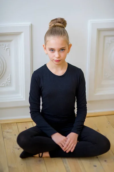Junge Balletttänzerin sitzt an der Wand — Stockfoto