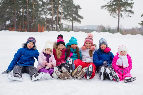 Groep van kinderen zitten op het ijs — Stockfoto