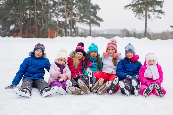 Groep van kinderen zitten op het ijs — Stockfoto