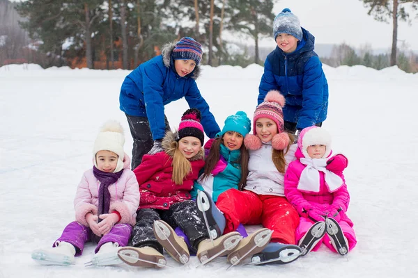 Groep van kinderen zitten op het ijs — Stockfoto