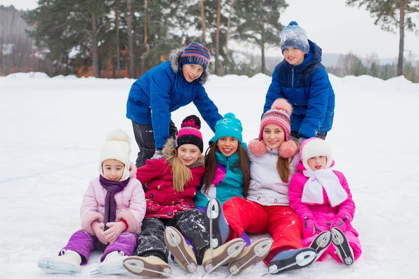 Groep van kinderen zitten op het ijs — Stockfoto