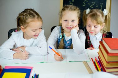 masada oturan üç genç kız öğrenciler