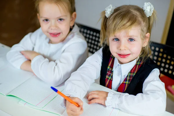 Retrato de dos colegialas sentadas a la mesa — Foto de Stock