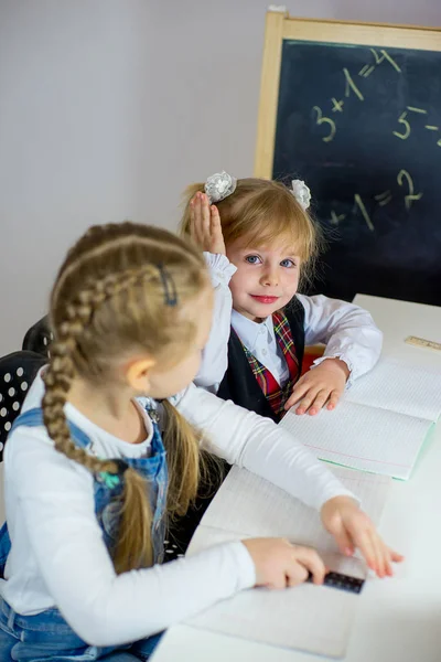 Porträt zweier junger Schulmädchen am Tisch — Stockfoto