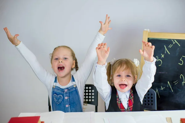 Retrato de dos colegialas sentadas a la mesa — Foto de Stock