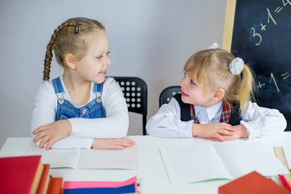 Retrato de dos colegialas sentadas a la mesa — Foto de Stock