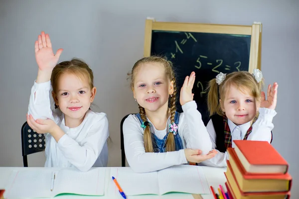 Tres jóvenes colegialas sentadas a la mesa — Foto de Stock