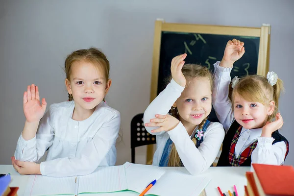 Tres jóvenes colegialas sentadas a la mesa — Foto de Stock