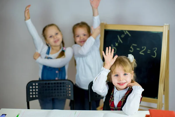 Tres jóvenes colegialas sentadas a la mesa — Foto de Stock