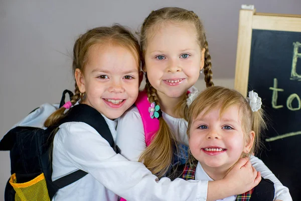 Trois jeunes écolières près du tableau noir — Photo