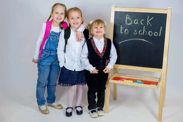 Trois jeunes écolières près du tableau noir — Photo
